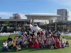 人工芝の広場でステージ出演者が集合写真を撮っている様子