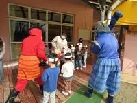 写真：怖いながらも 鬼に豆を投げつける 未満児クラスの子どもたち