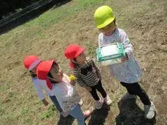 写真：虫かごをみる子どもたち