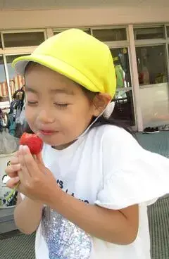 写真：目を閉じてイチゴを味わう子