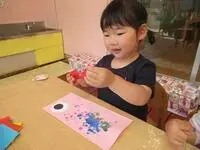 写真：指に絵の具を付けてこいのぼり制作する子