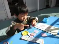 写真：でんぷんのりを指で拭っている男の子