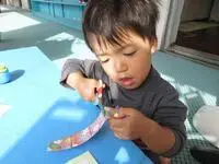 写真：ハサミで紙を切っている男の子