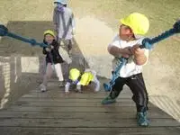 写真：ロープを引っ張りながら遊具の坂を上る子たち