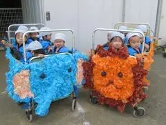 写真：ゾウとライオンを模した山車に乗った子どもたち