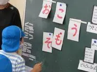 写真：黒板に貼られたヒントを見ている子