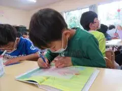 写真：真剣に絵を描く子供