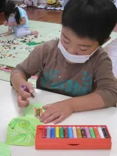 写真：クレヨンをもって、絵をかいている子