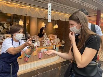 写真：仲見世商店街でお菓子を試食する様子