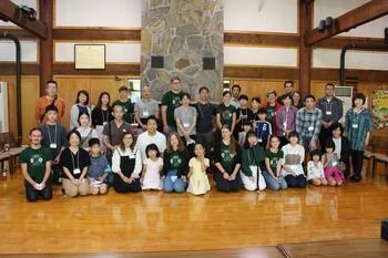 写真：ホストファミリーと団員の集合写真