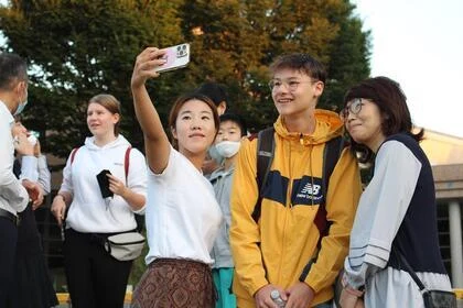 写真：ホストファミリーと団員が記念撮影をする様子