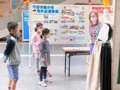 写真：子どもたちに民族衣装を説明している様子