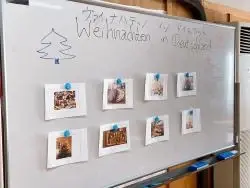 写真：クリスマスに関する写真が貼られたホワイトボード