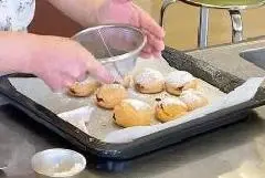 写真：菓子パンに粉砂糖をかけている様子