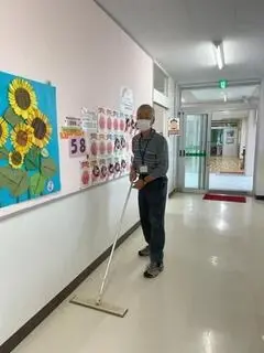 写真：校内のモップ掛けをしている様子