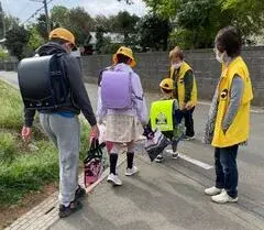 写真：黄色いベストを着て、子供たちと挨拶