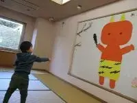 写真：壁面飾りに豆をまいているお子さん