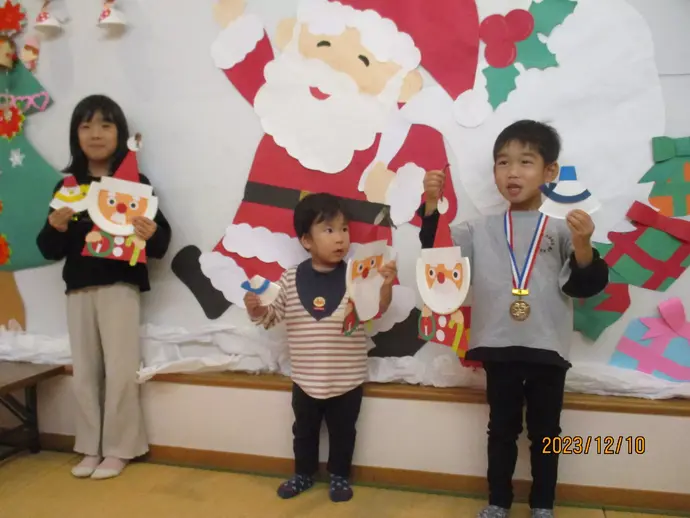 できあがったサンタさんと、おはなしのへやで写真撮影する子どもたち