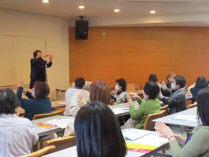 先生と一緒に手遊びする参加者たち