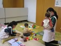 写真：託児所でおもちゃで遊ぶ子供たちと先生