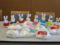 写真：色とりどりのうさぎのぬいぐるみをテーブルに並べた様子