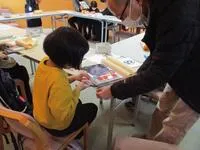 写真：手伝ってもらってブッカーを貼る様子