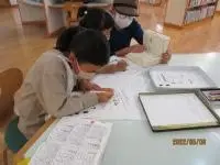 写真：辞典を使って考えている親子