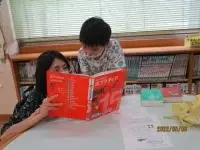 写真：百科事典を使ってを調べている親子