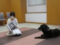 写真：ジョン君と1対1で読み聞かせしている子ども