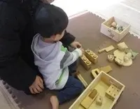 写真：木製のブロックを組み立てる子