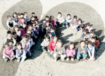 写真：10周年を祝して、保育所の園児が10という数字をかたどって並んでいます。