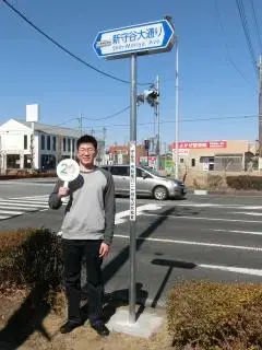 写真：新守谷大通りの看板と愛称採用者