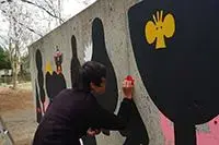 写真：20か所目を描くイヌイマサノリさん