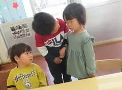 写真：年長児が顔をのぞきこむ様子