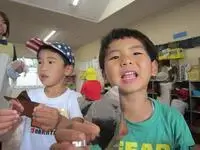 写真：笑顔で見つけた星を先生に報告する子