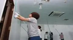 写真：ママさんたちが拠点のペンキ塗りをしている様子