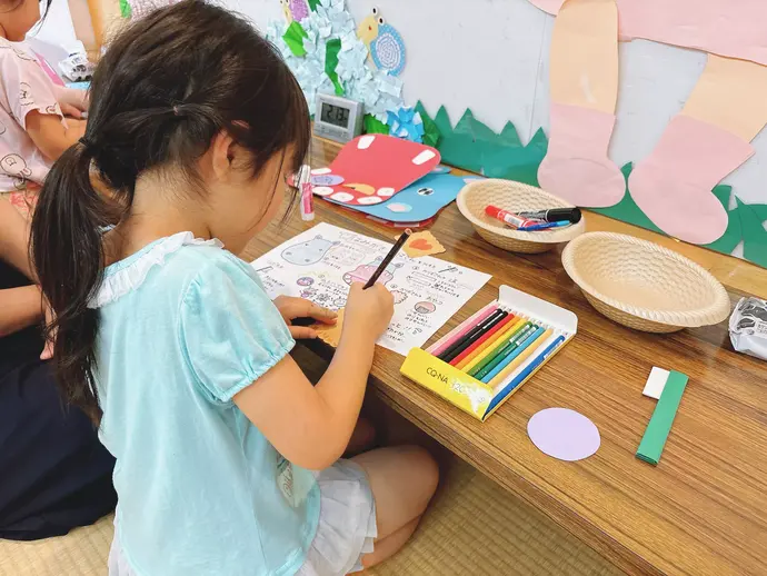お菓子の色塗りをする子ども