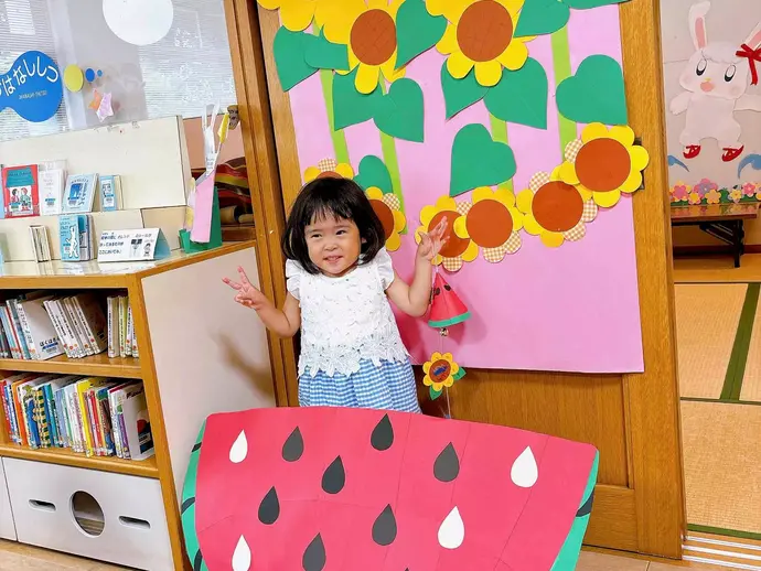 壁飾りと写真撮影する子ども