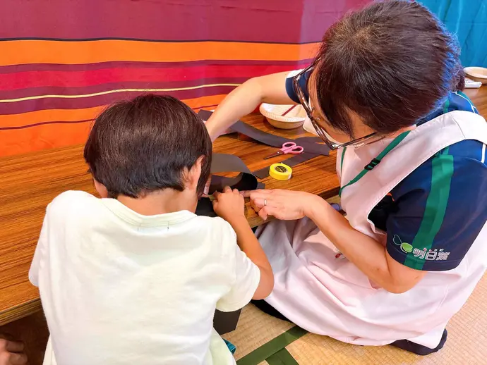 頭のわっかを一生懸命作る子ども