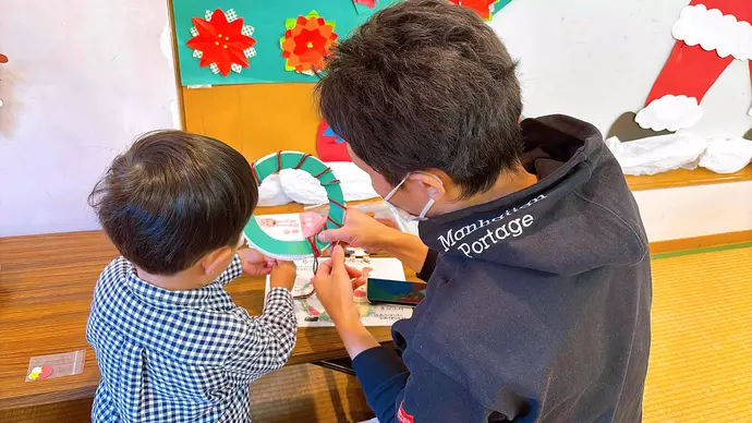 リースを飾り付ける親子