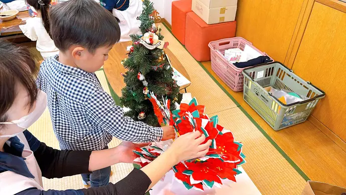 お土産のポインセチアを選ぶ子ども