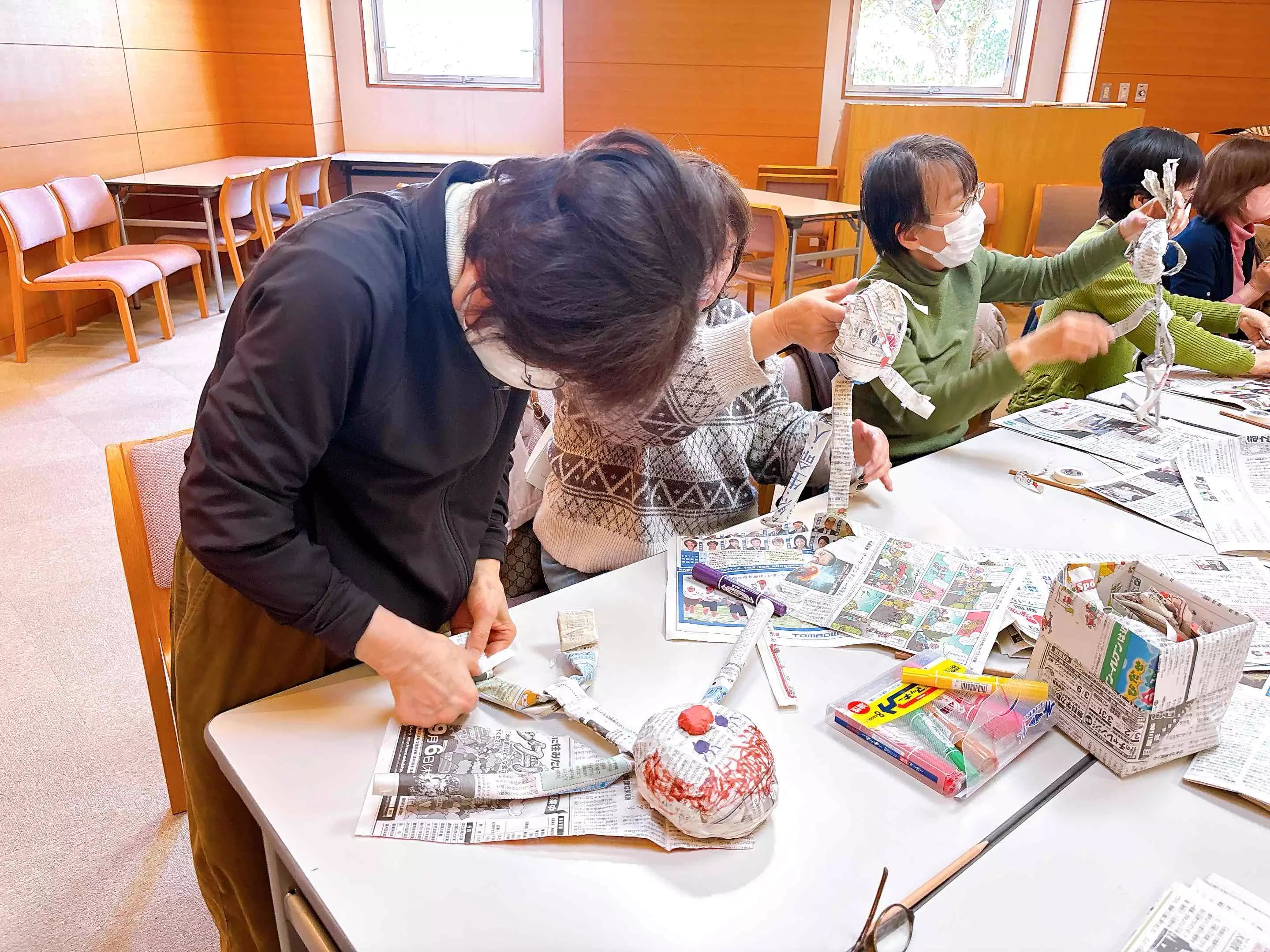 受講生が新聞人形を作っている様子