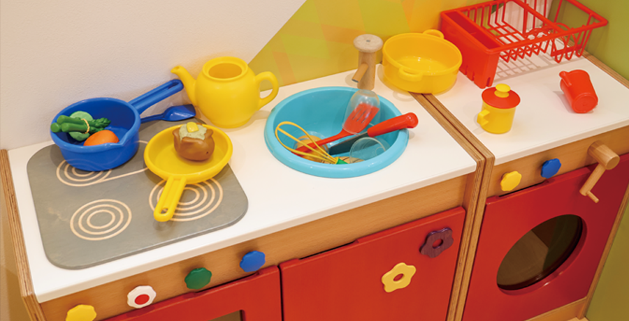 写真：施設内おもちゃ。キッチンのセットフライパンや調理器具のおもちゃがある