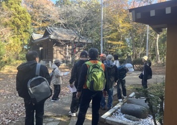 浅間神社の力石の説明を聞く参加者