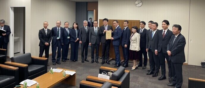 木原内閣官房長官に書類を渡すつくばエクスプレス利用建設促進議員連盟